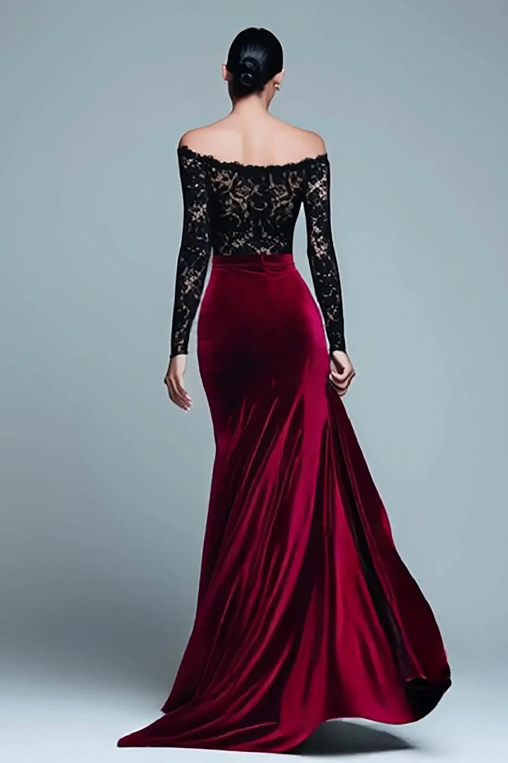 Side view of model in black and burgundy velvet mermaid gown.
