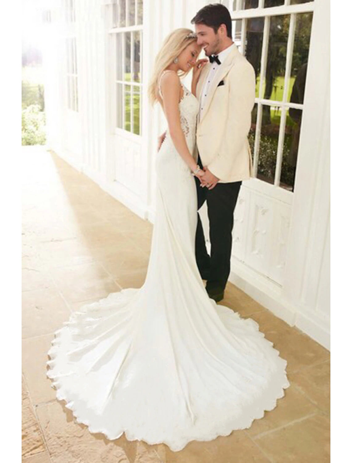 Side view of a bride wearing a white trumpet wedding dress.