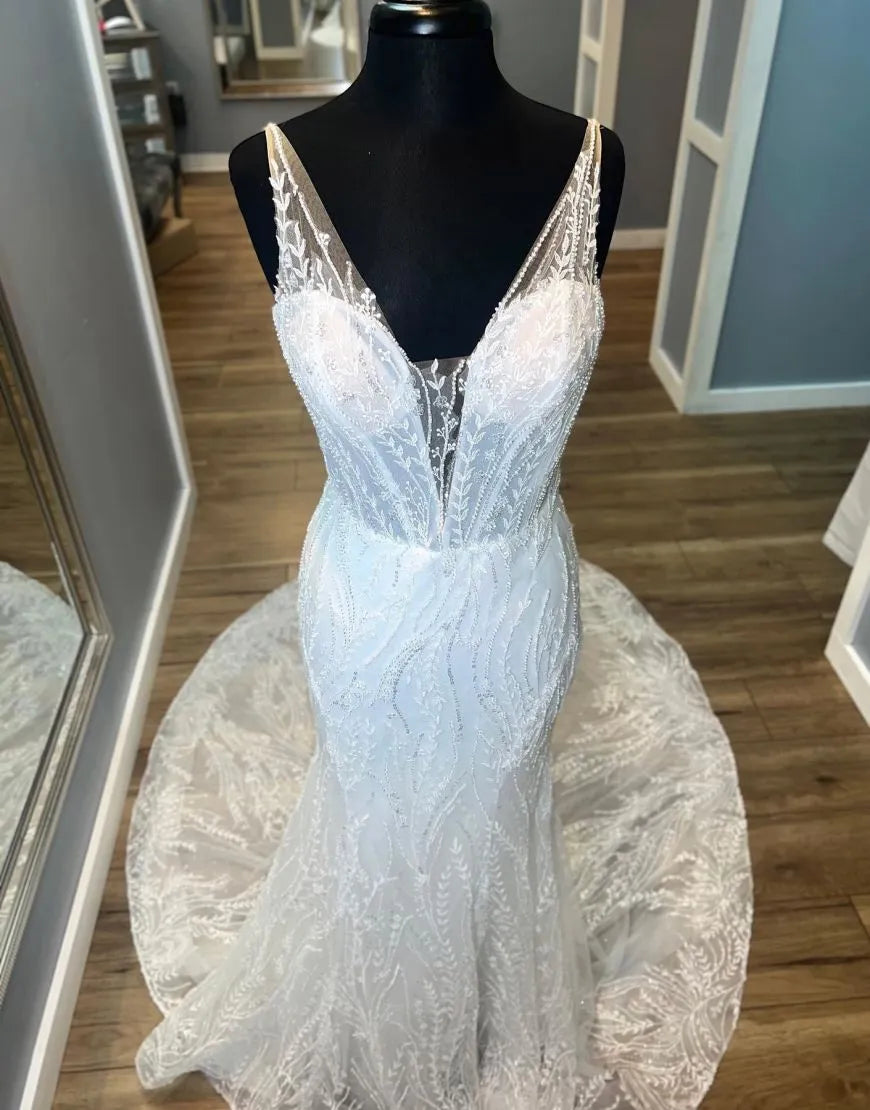 Elegant Ivory Mermaid V-Neck wedding dress with lace details and open back.