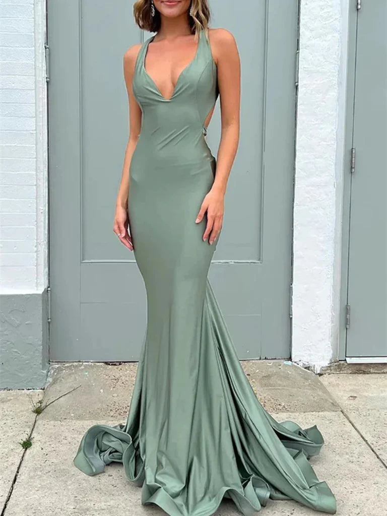 A woman wearing an elegant long mermaid V-neck open back prom dress.