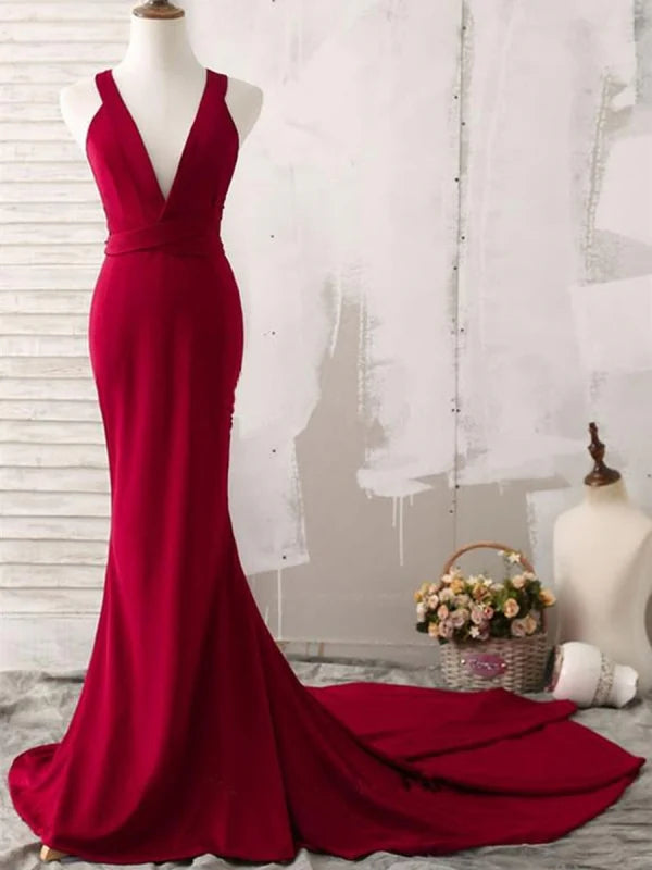 Woman in elegant mermaid V-neck satin prom dress with open back and train.