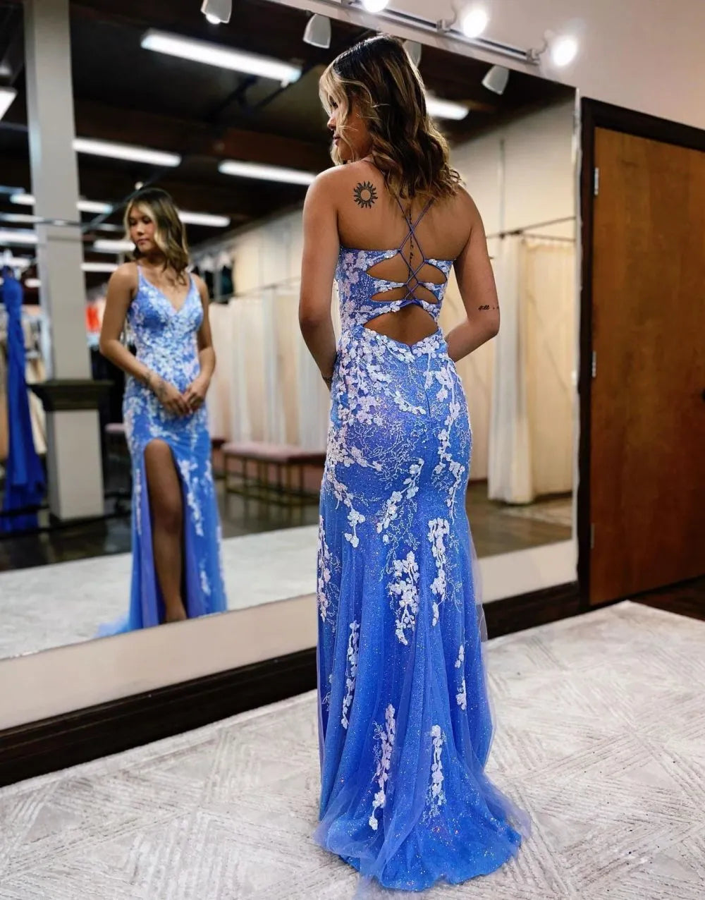 Back view of the mermaid V-neck prom dress, highlighting the flowing train and appliques.