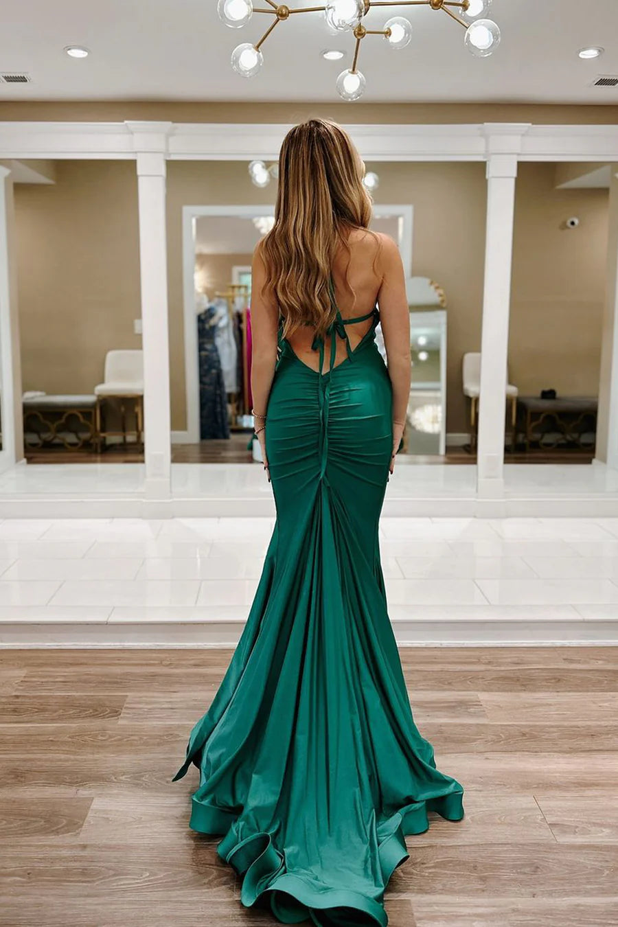 Close-up of the sage green satin fabric and V-neckline of the dress.