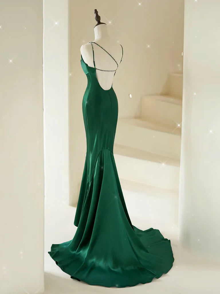 Back view of a woman in a navy blue mermaid satin prom dress.