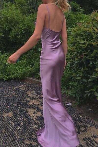 Woman posing in a long mermaid satin dress, showcasing the V-neck and high slit.