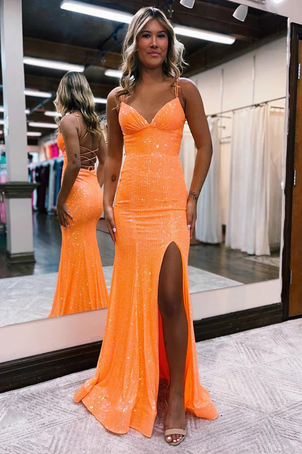 Model in a dazzling mermaid sequined prom dress with V-neck and high slit.