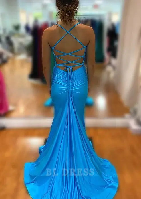 Side view of a woman posing in a blue mermaid evening dress, highlighting the V-neck and front split.