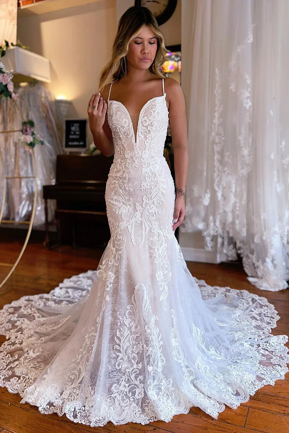 Elegant ivory mermaid lace wedding dress with spaghetti straps and V-neck.