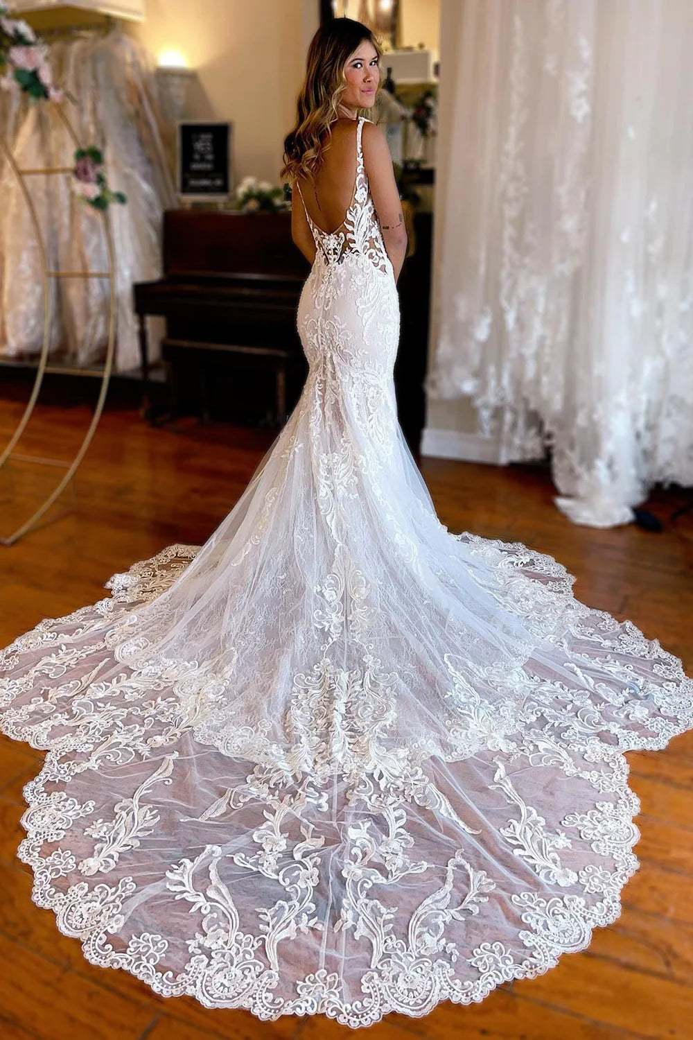 Back view of an ivory mermaid lace wedding dress with spaghetti straps.