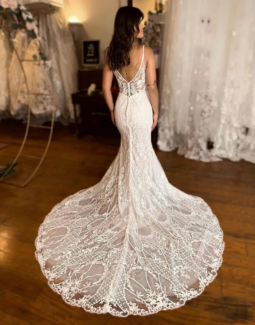 Back view of a mermaid lace wedding dress featuring a long train.