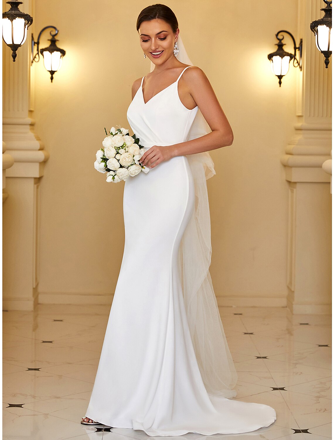 Close-up of the V-neckline and spaghetti straps on a reception wedding gown.