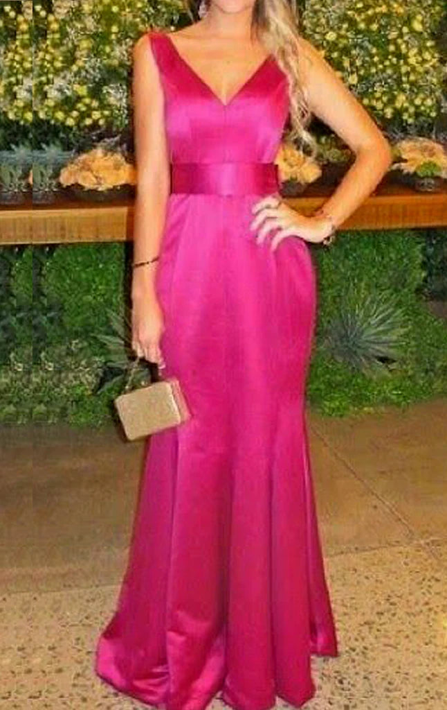 Woman wearing an elegant mermaid V-neck satin long prom dress.