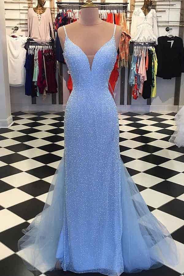 Woman wearing an elegant mermaid formal dress with spaghetti straps and beaded details, front view.