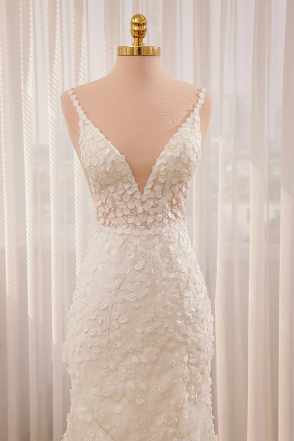 Romantic mermaid wedding dress with lace appliques and straps.