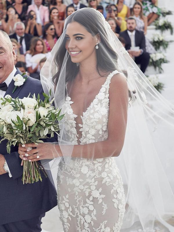 Close-up of lace appliques and V-neckline on a wedding dress.