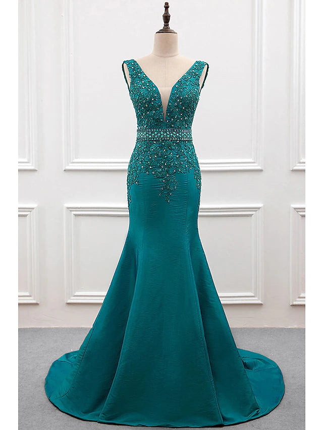 Woman wearing an elegant mermaid V-neck taffeta evening gown with pearls embroidery and a court train.