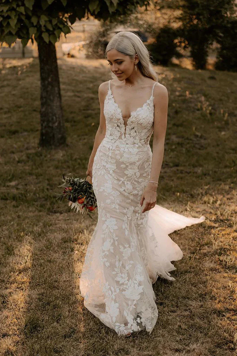 Elegant mermaid V-neck wedding dress with intricate appliques and flowing tulle skirt.
