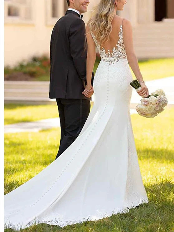 Full-length view of a bride in a sleeveless mermaid V-neck wedding gown, highlighting its sophisticated silhouette.