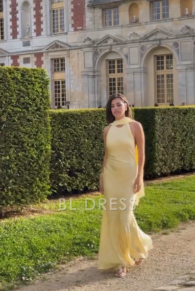 Model wearing an elegant yellow chiffon mermaid formal dress with a V-neckline.