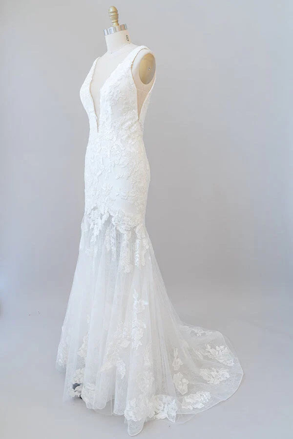 Full length view of a mermaid wedding dress with V-neck and lace.
