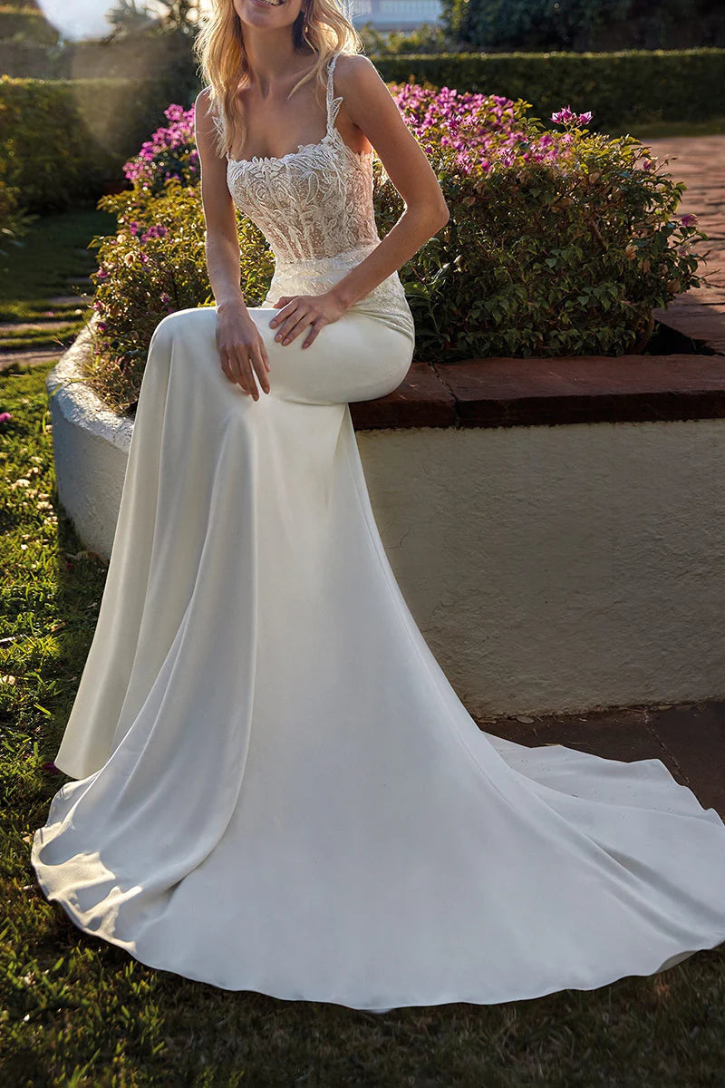 Side profile of a bride wearing a mermaid wedding gown with intricate lace appliques.
