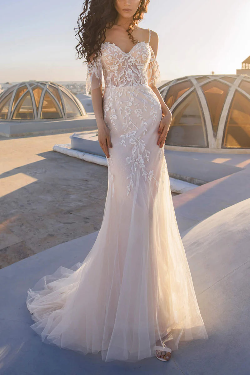 Mermaid wedding dress with spaghetti straps and lace appliques, front view.