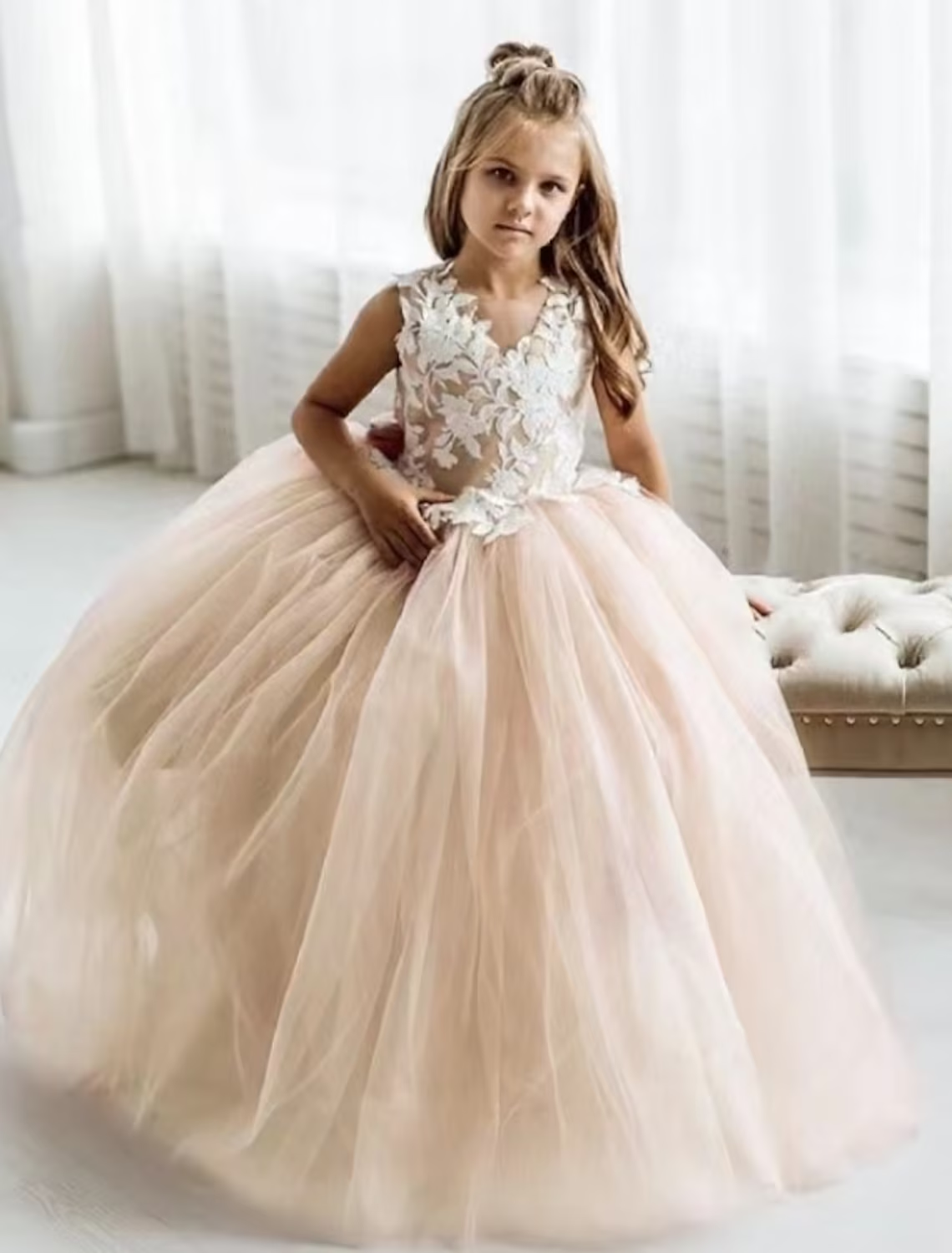 Girl wearing a white sleeveless mesh princess party dress.