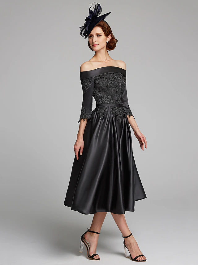 Detail of the 3/4 length lace sleeve and off-shoulder neckline of the navy dress.
