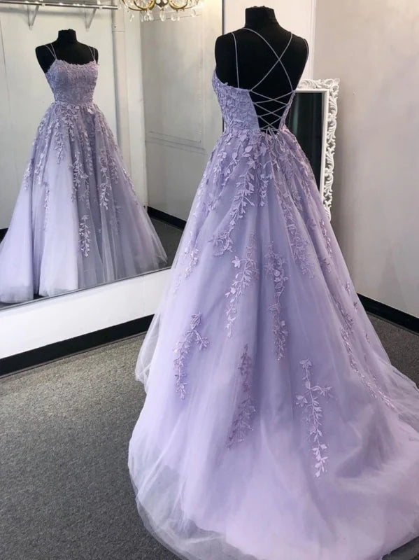 Woman wearing an elegant navy blue backless lace A-line long prom dress.