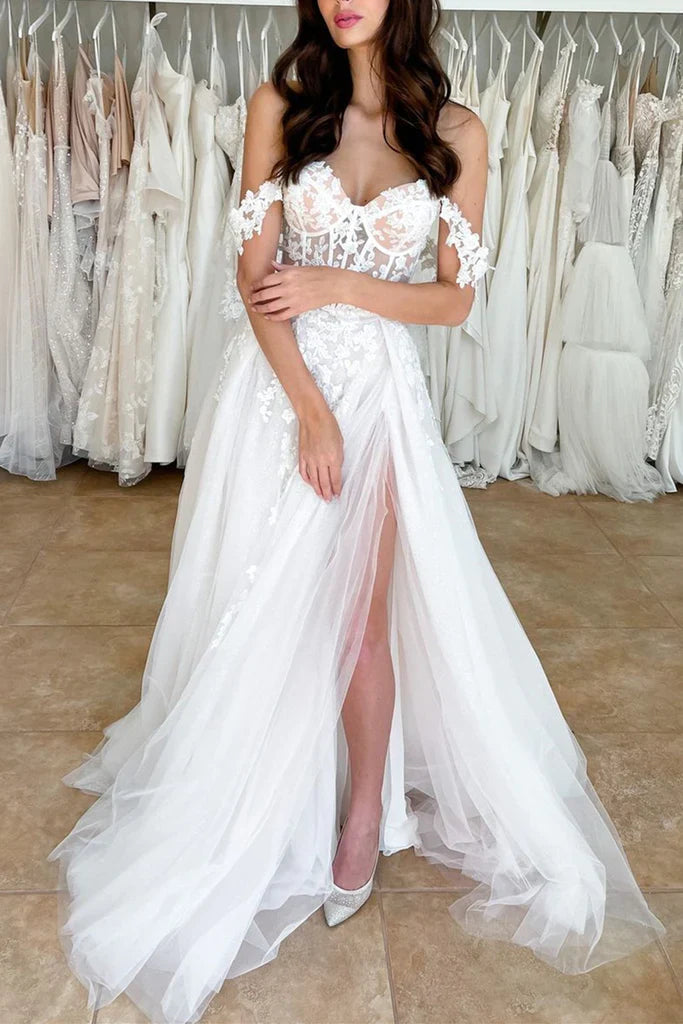 Back view of an off-shoulder lace wedding dress, showing the flowing train and delicate lace details.