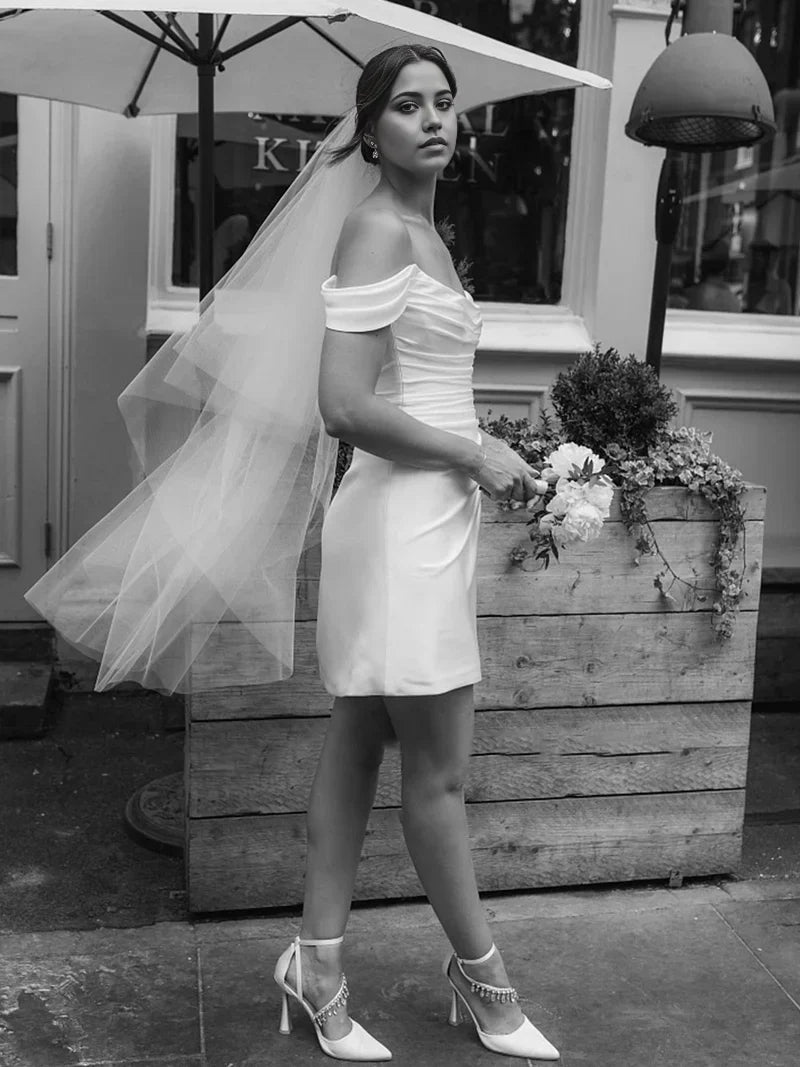 Close-up of the cowl neck and off-shoulder detail of the satin dress.