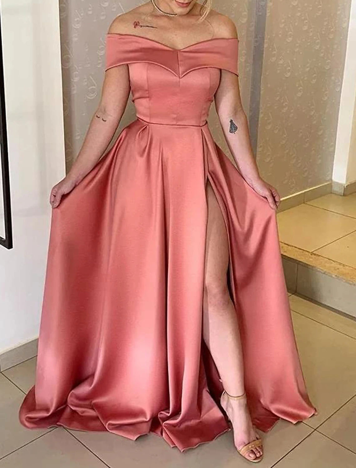 Close-up of the off-shoulder neckline and satin fabric detail on the formal evening dress.