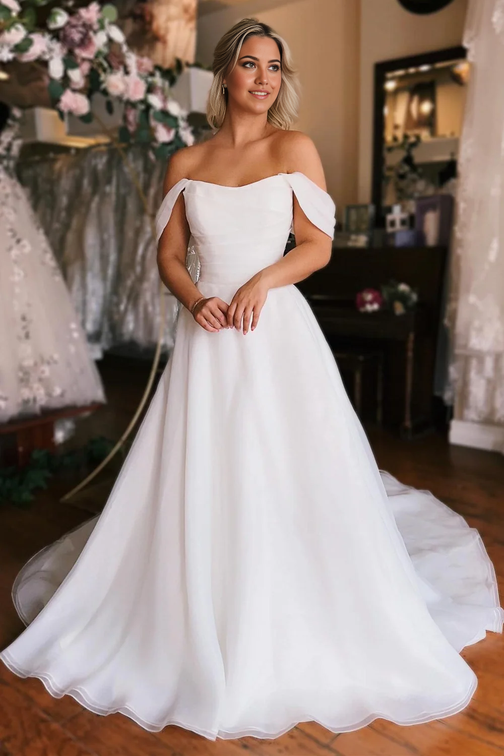 Elegant off-shoulder A-line white wedding dress with a high slit on a model.