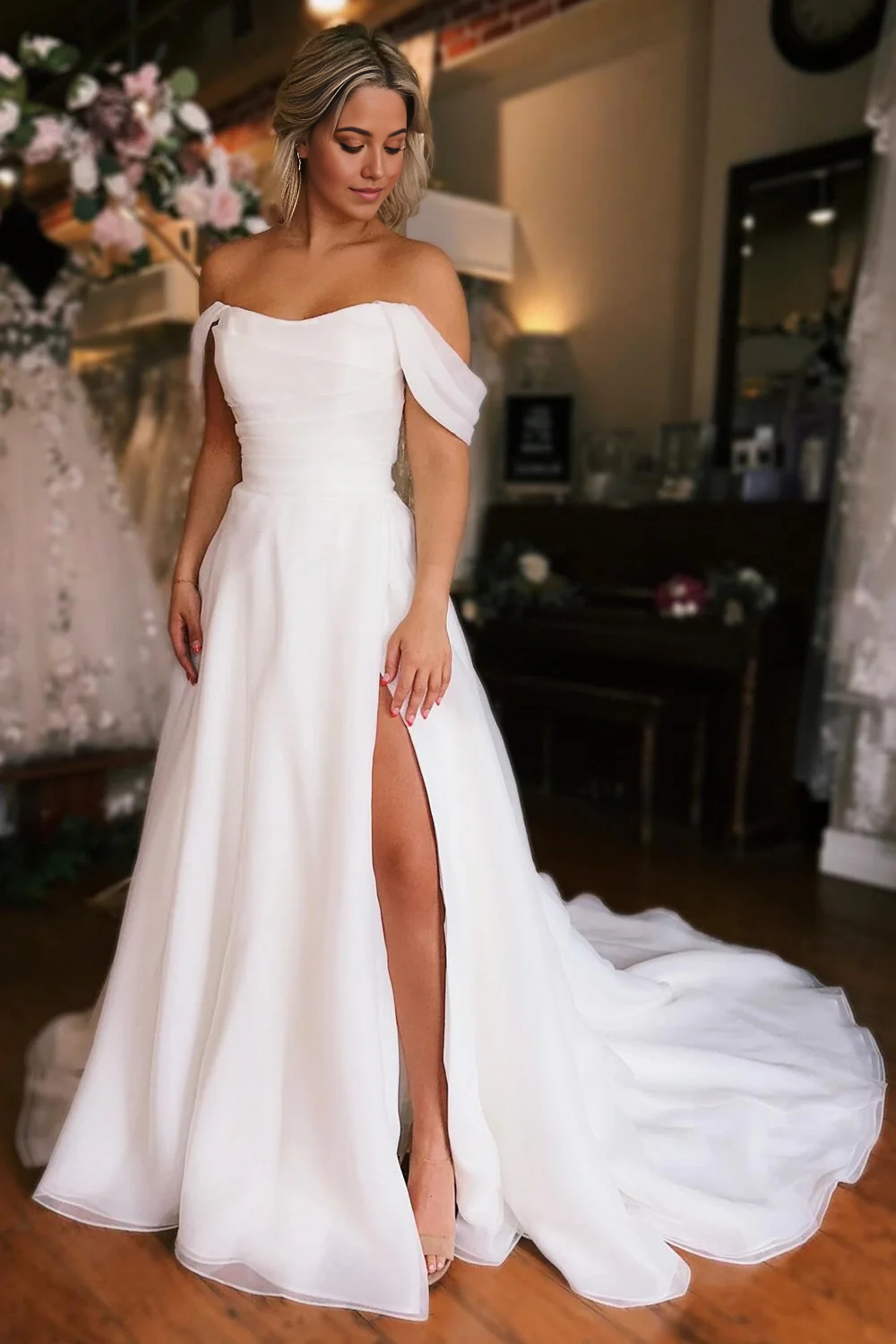 Back view of the elegant off-shoulder A-line white wedding dress with a high slit.