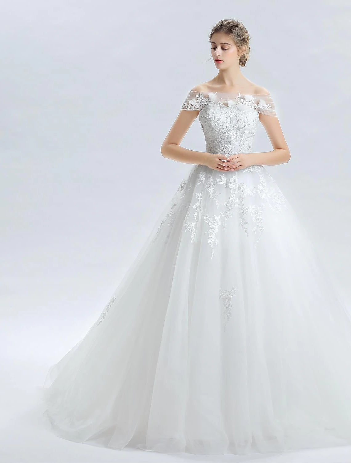Elegant off-shoulder ball gown wedding dress with lace beading and cathedral train.