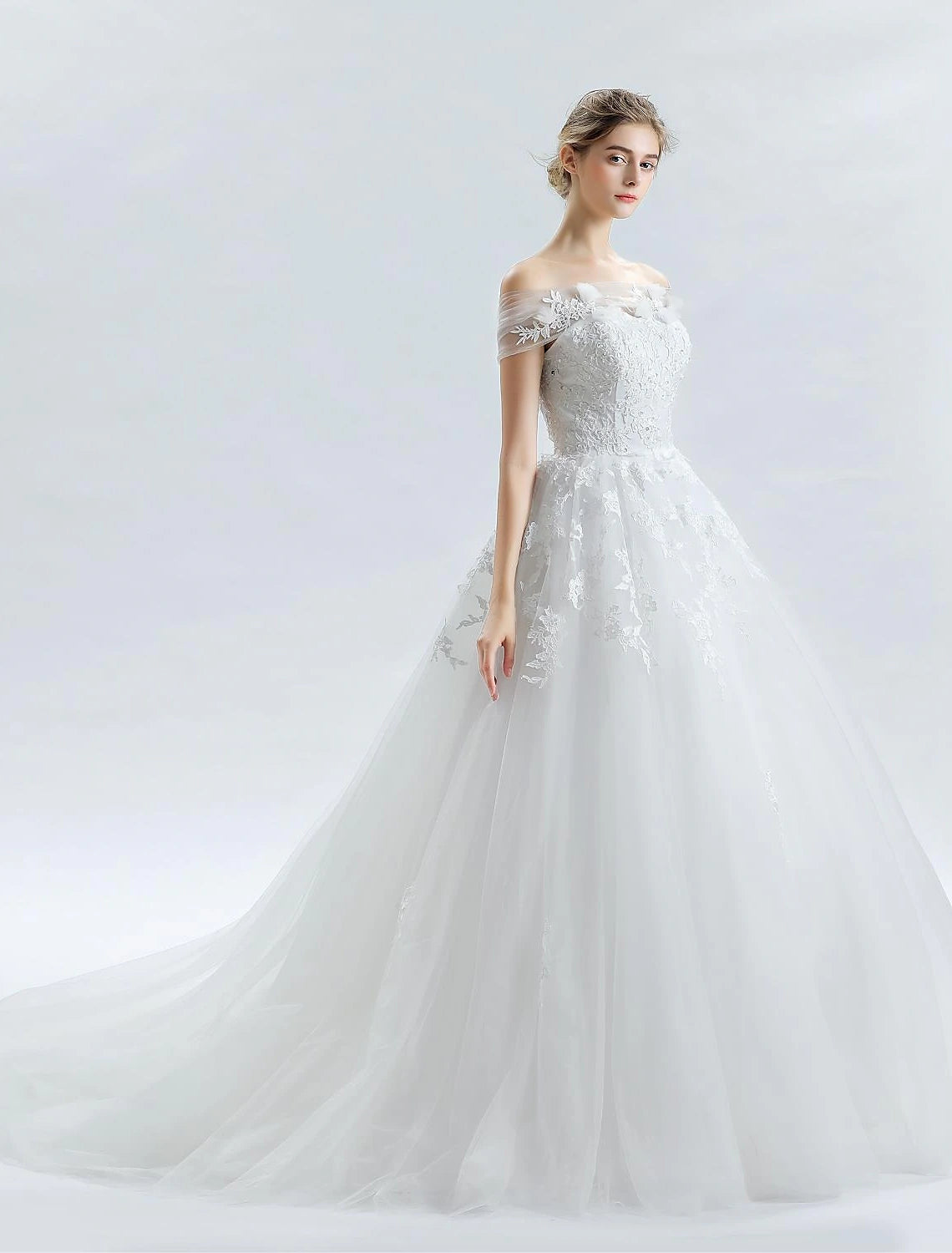 Side profile of a bride wearing the off-shoulder ball gown wedding dress.