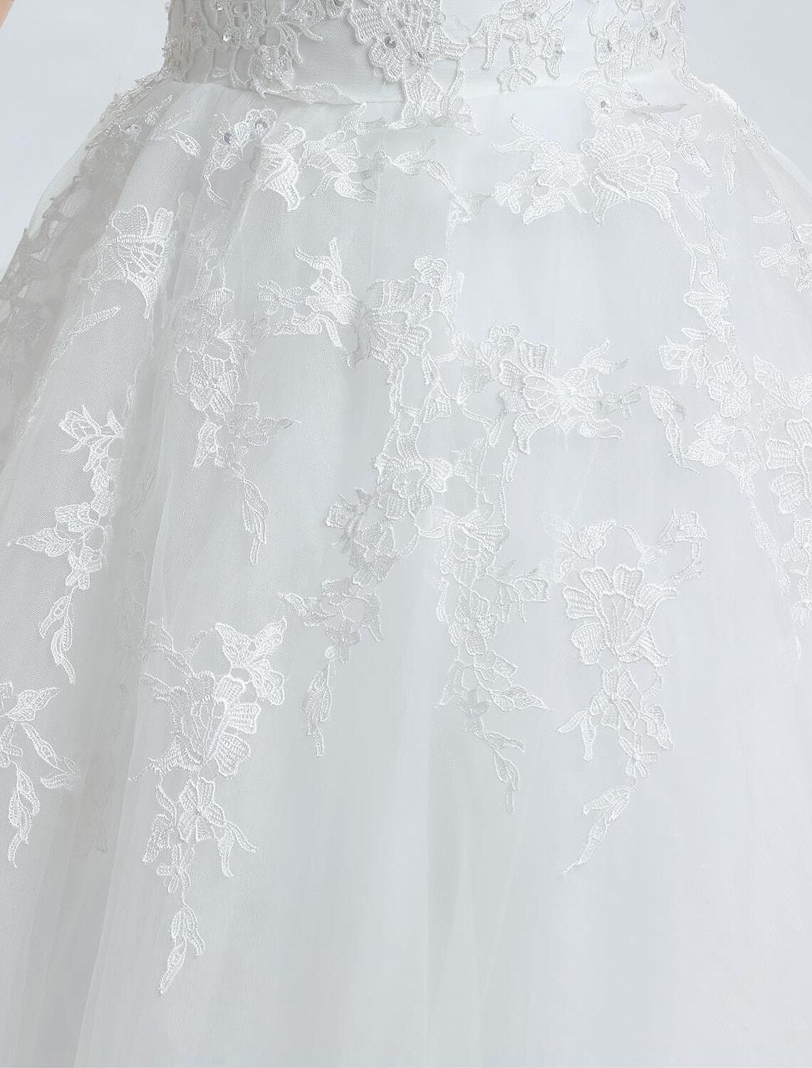 Detail of luxurious satin fabric and intricate beading on the wedding dress.