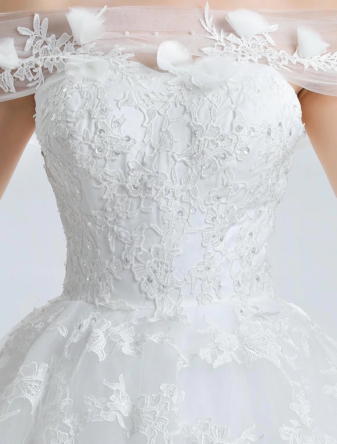 Bride posing gracefully in the elegant off-shoulder ball gown.
