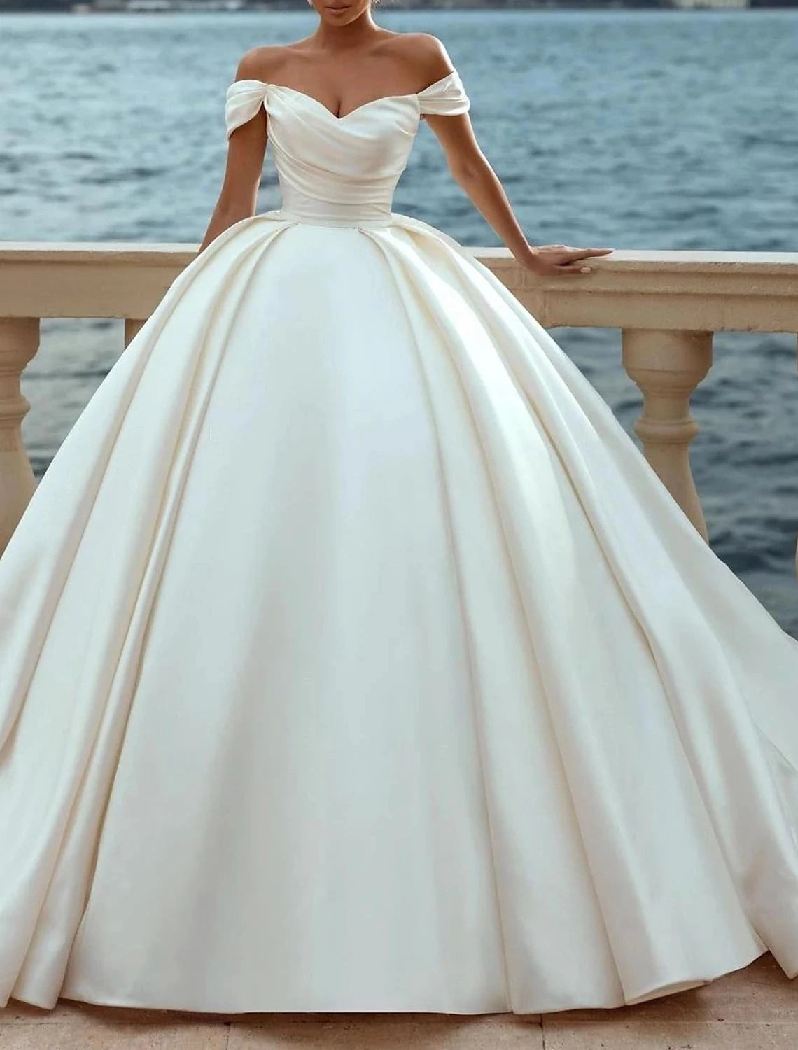 Side view of the off-shoulder satin bridal gown with ruched details.