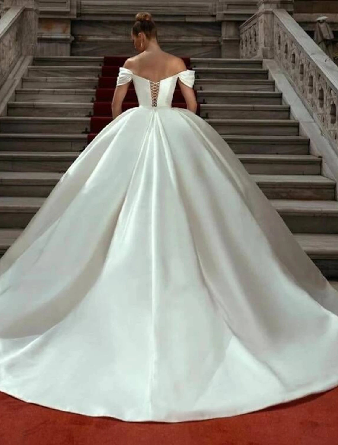 Close-up of the off-shoulder neckline and cap sleeves on the satin wedding dress.