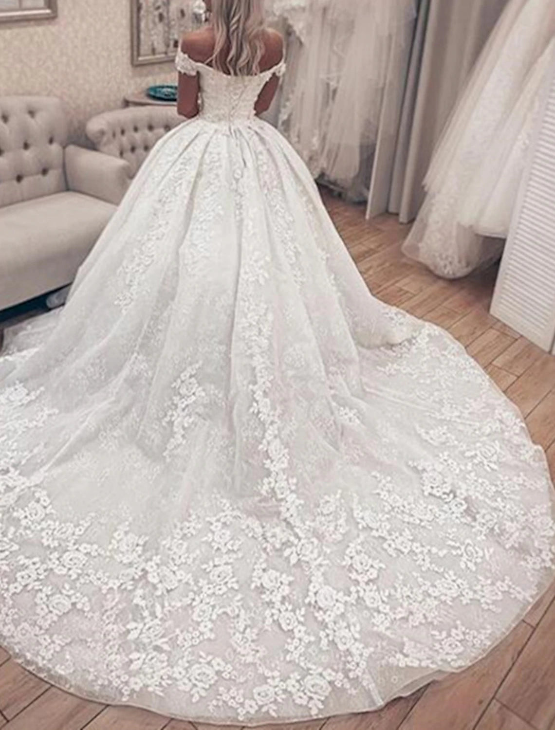 Close-up of the lace appliques and off-shoulder neckline on the wedding dress.