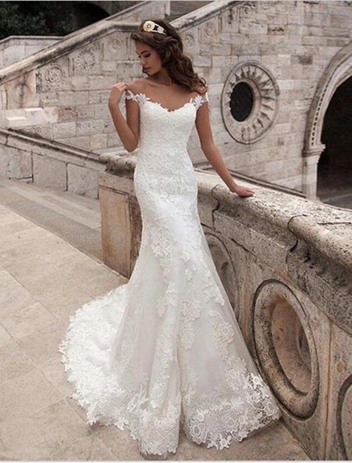 Elegant off-shoulder mermaid wedding gown with cap sleeves and lace appliques.
