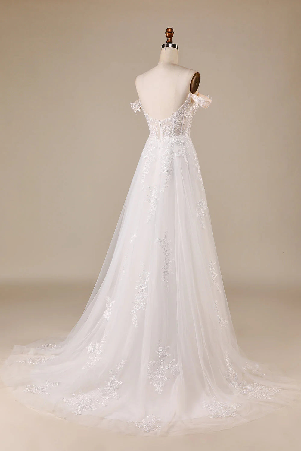 Elegant ivory bridal gown with off-shoulder neckline and flowing tulle skirt.