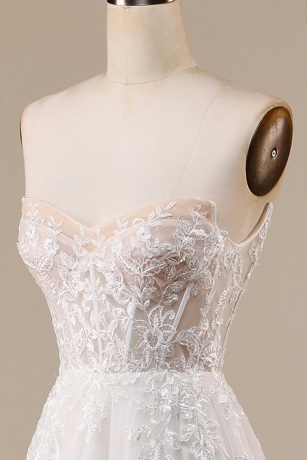Close-up of the corset bodice and off-shoulder detail on an ivory wedding dress.