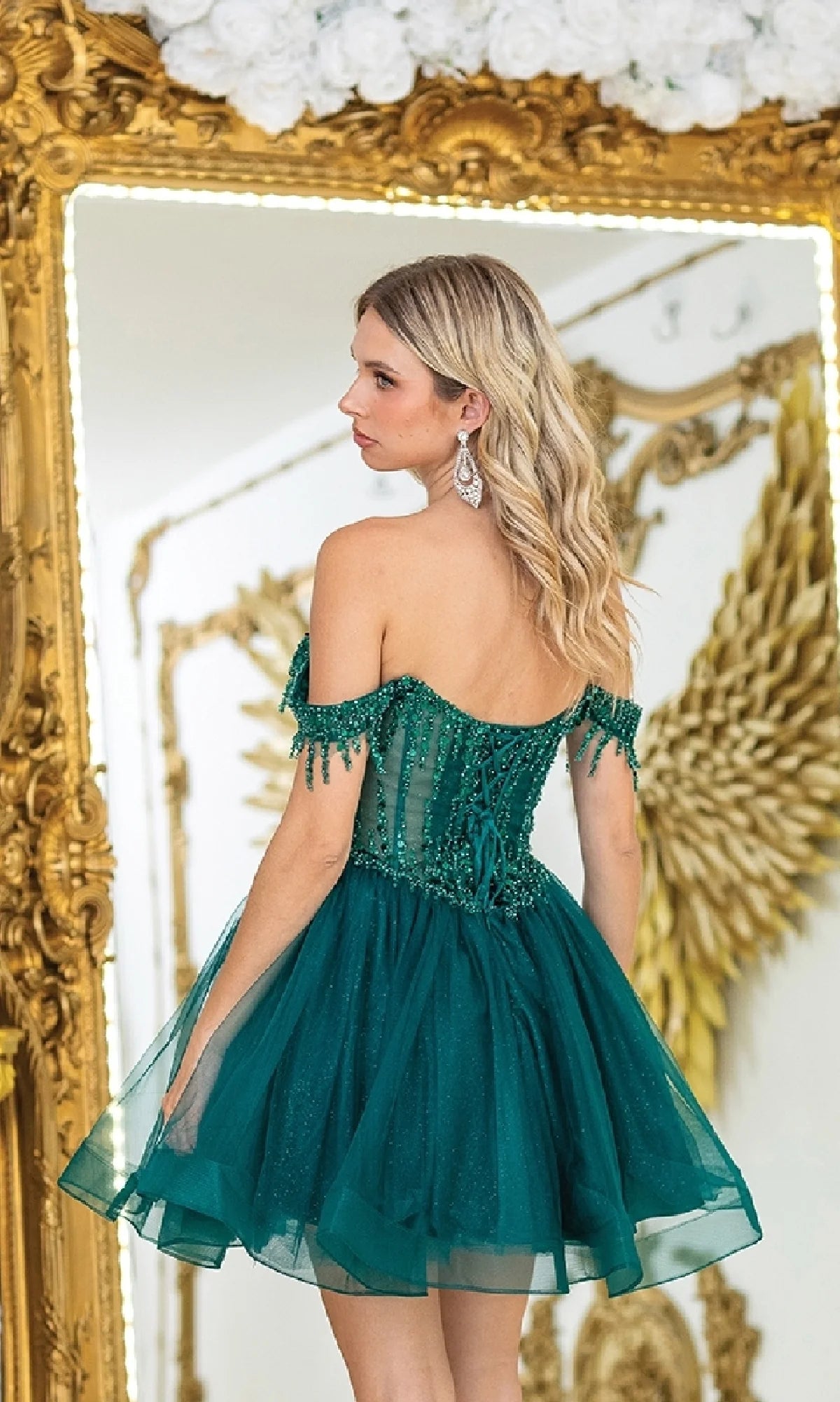 Close-up of the sequin corset bodice and voluminous tulle skirt of the emerald green dress.