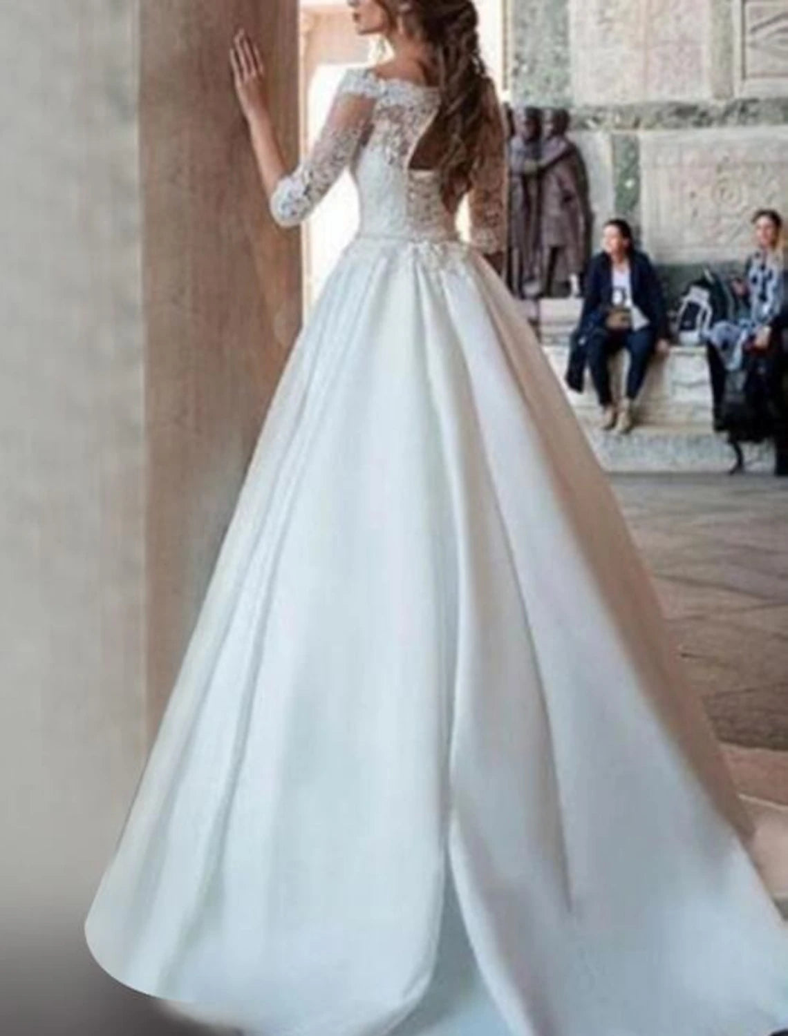Back view of the satin wedding dress, showing the sweep train and intricate appliques.