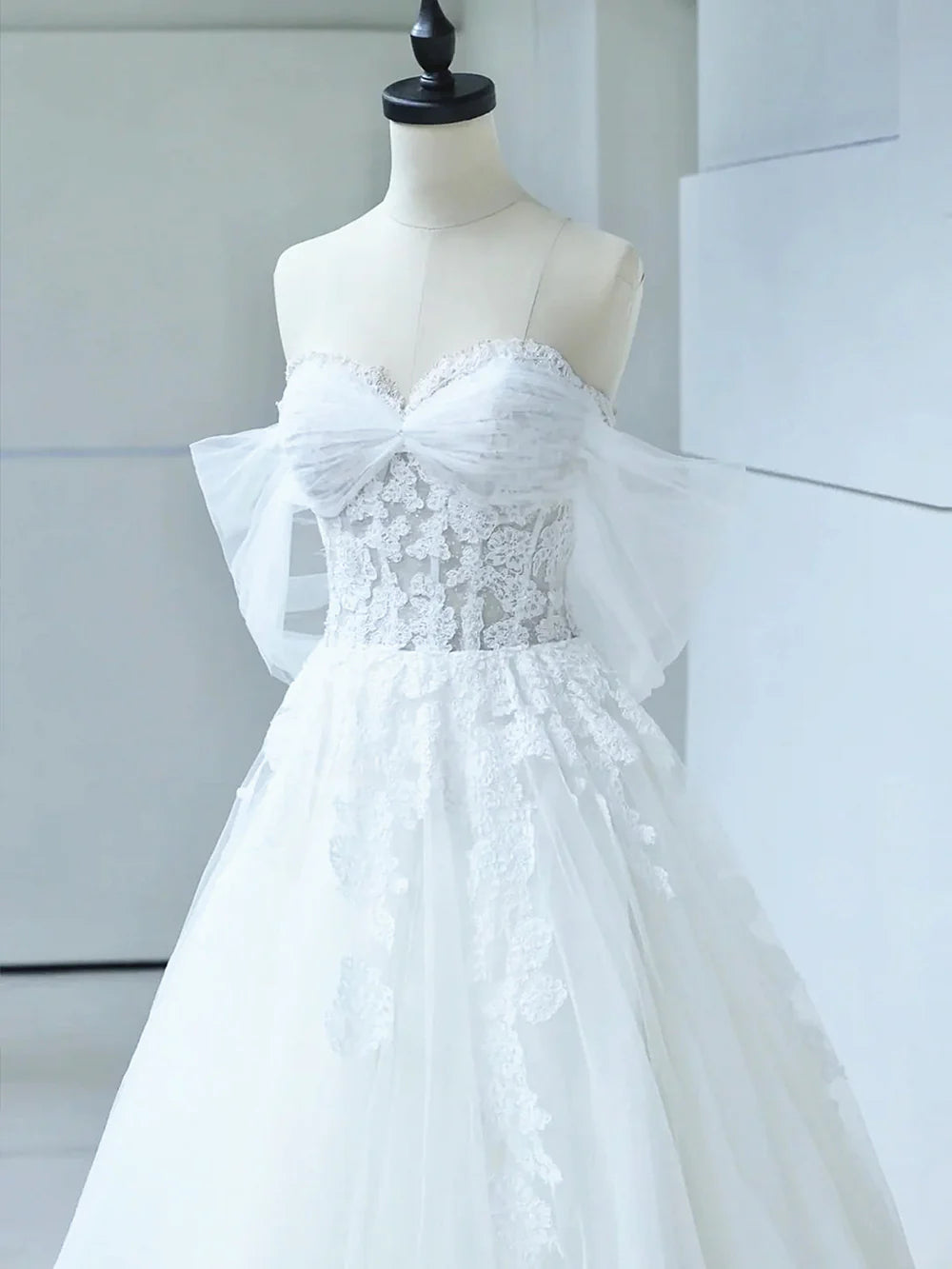 Full length view of elegant off-shoulder wedding dress.
