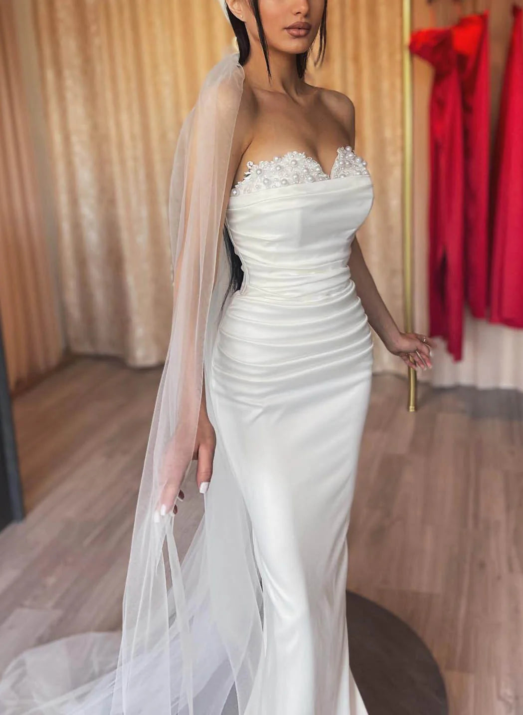 Side view of the off-shoulder lace sheath wedding dress.
