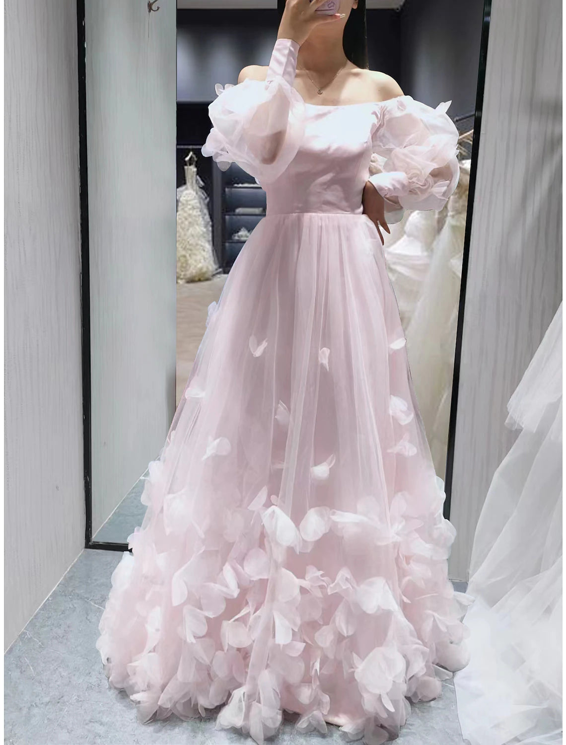 Full view of the floral applique off-shoulder long sleeve ball gown.