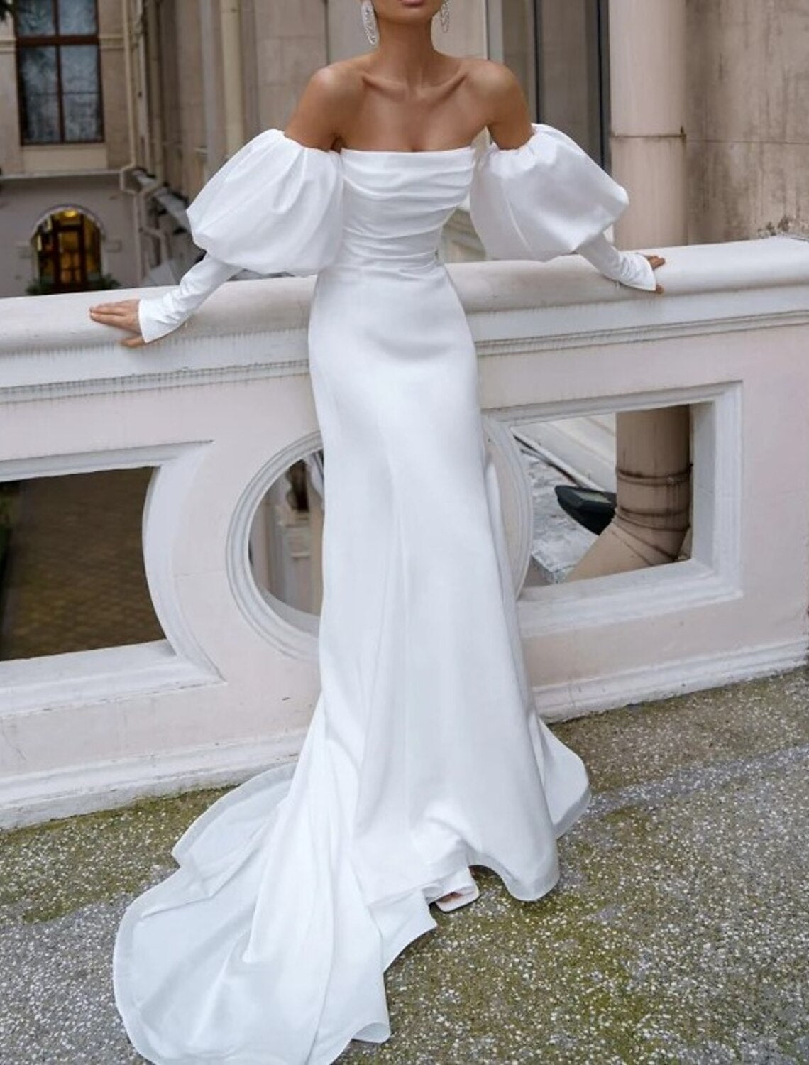 Close-up of the ruched detail on the off-shoulder long sleeve satin mermaid wedding dress.